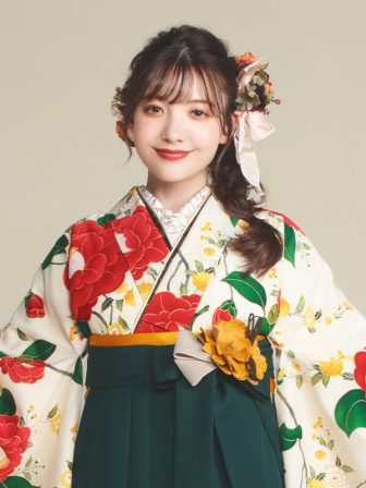 着物と袴のレンタルセット商品画像。袴は緑色。着物はオフ色。乙女椿柄のデザイン。上半身アップ画像。