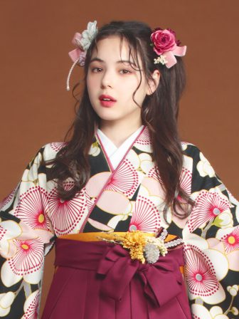 着物と袴のレンタルセット商品画像。袴はえんじ色。着物は黒色。梅柄のデザイン。上半身アップ画像。