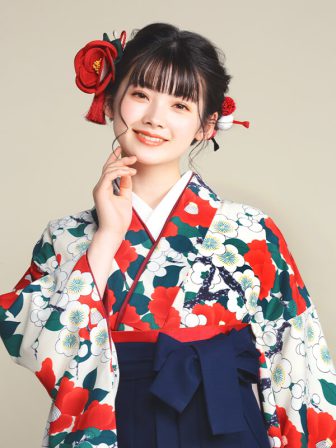 着物と袴のレンタルセット商品画像。袴は紺色。着物はベージュ色。梅椿柄のデザイン。上半身アップ画像。