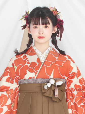 着物と袴のレンタルセット商品画像。袴はブラウン色。着物はオレンジ色。椿柄のデザイン。