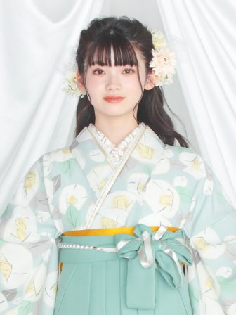 着物と袴のレンタルセット商品画像。袴はミントグリーン色。着物は水色。りんご椿柄のデザイン。上半身アップ画像。